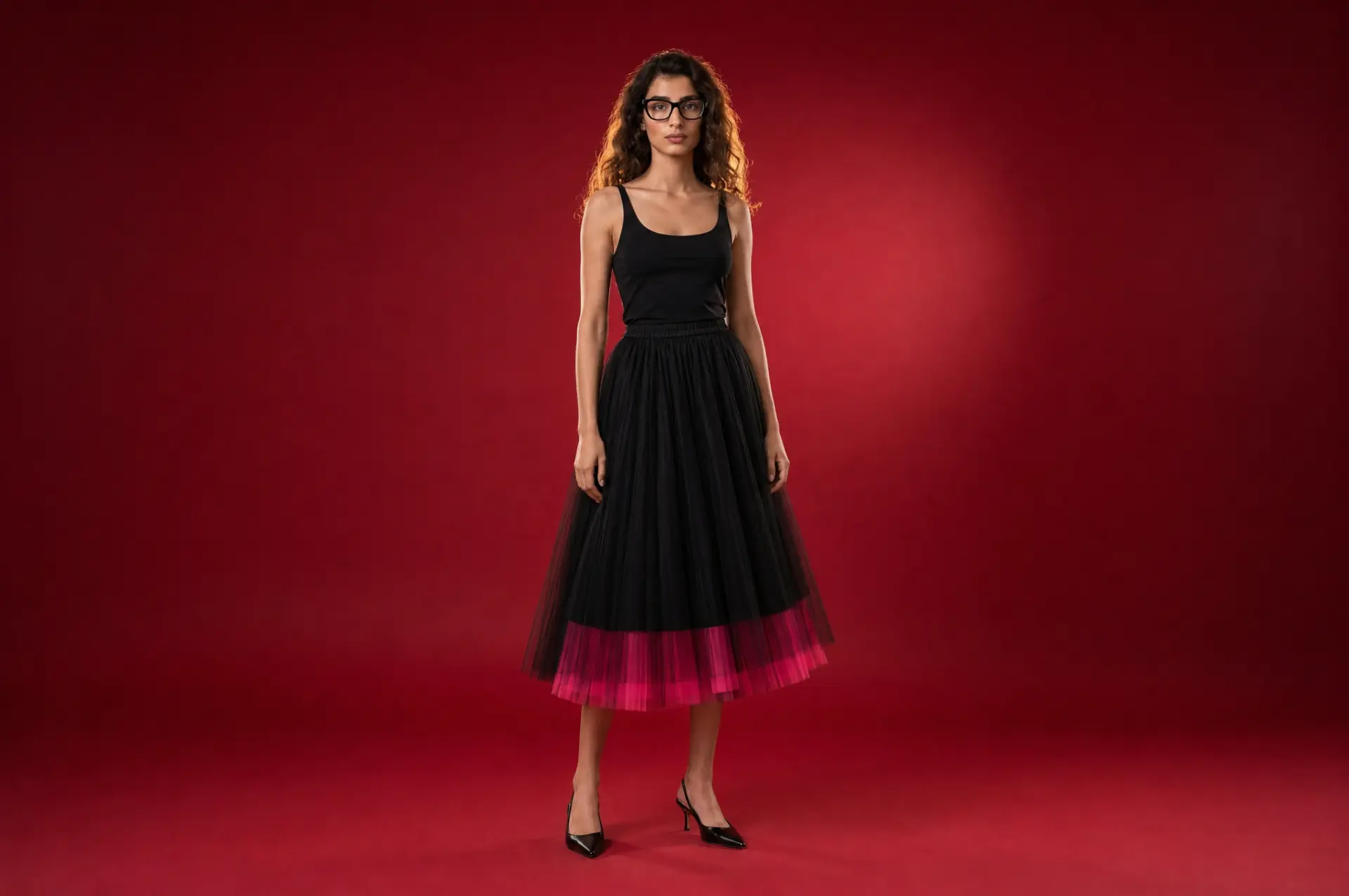 Model wearing the House Cardi black tulle skirt on a red backdrop